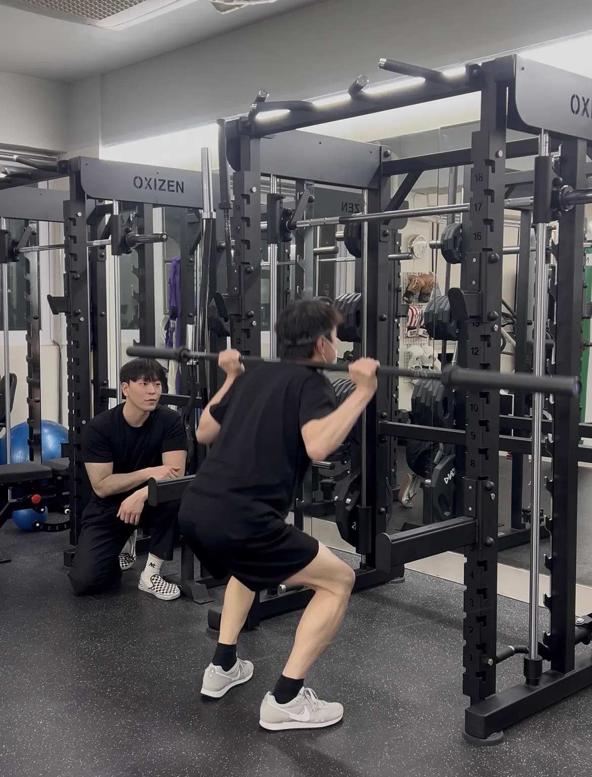 Coach guiding a member through weight training at BODY SMITH private gym