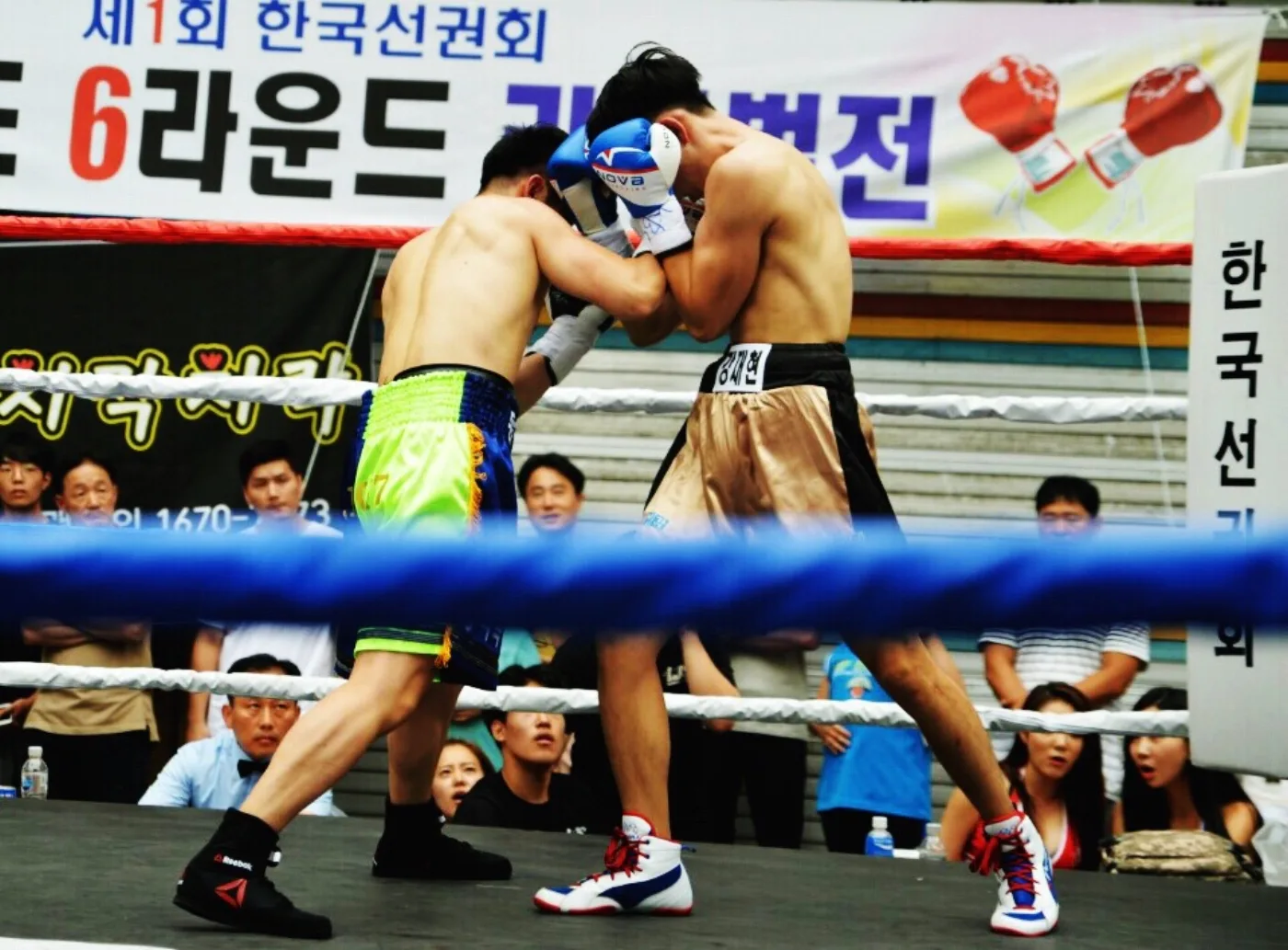 Coach Kang Jaehyun competing in a boxing ring during a Korean boxing match