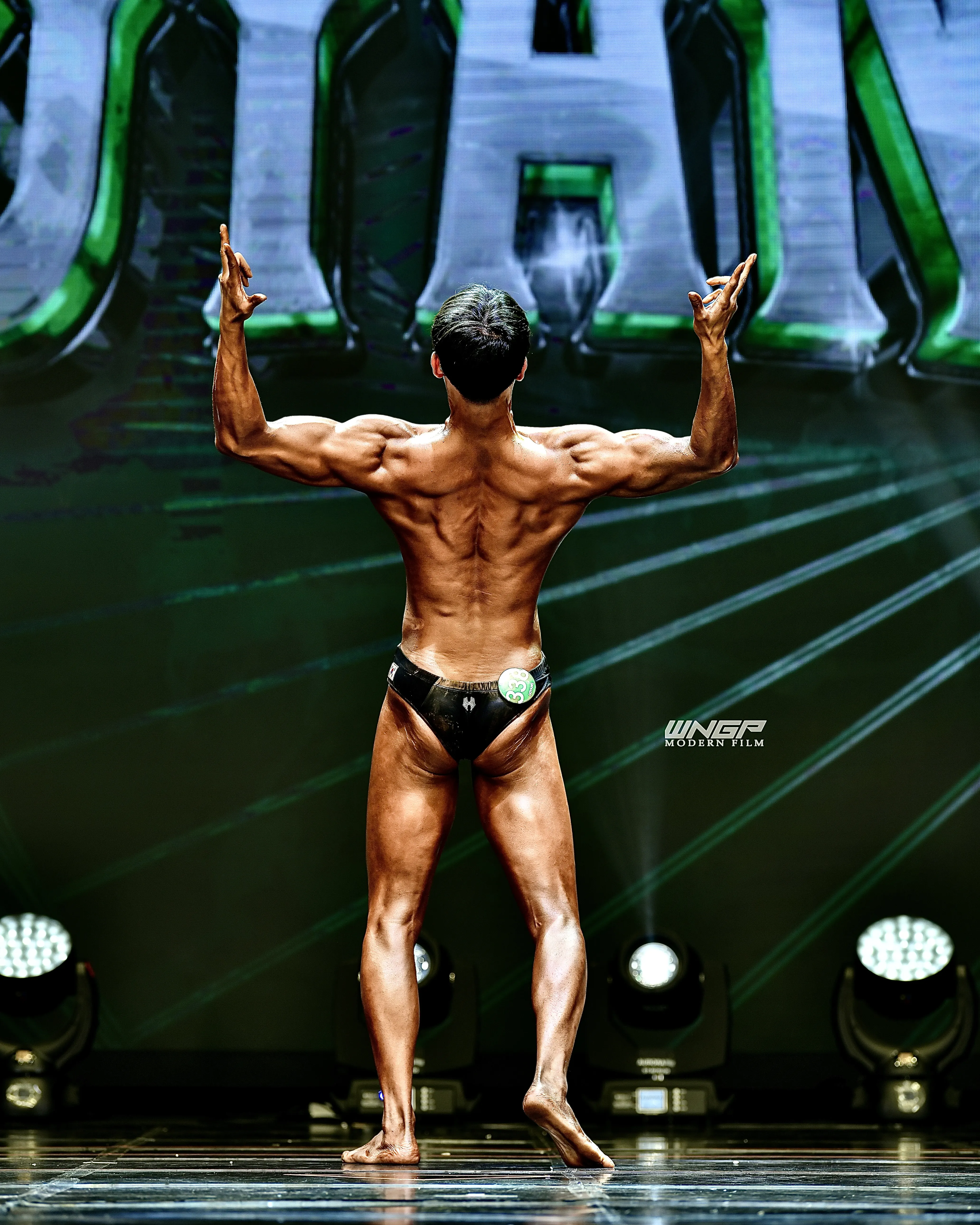 Coach Kang Jaehyun back double bicep pose at bodybuilding competition