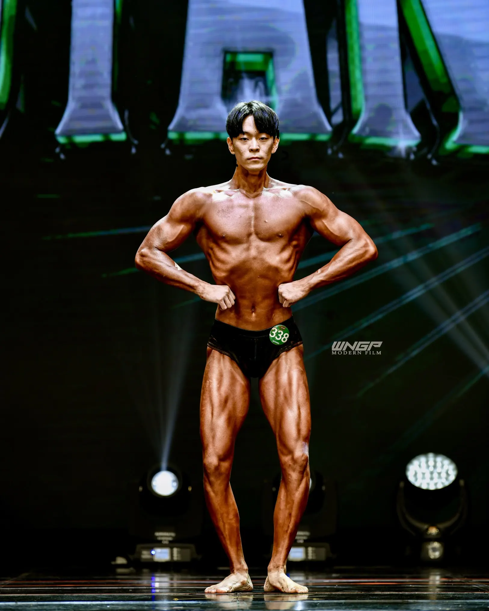 Coach Kang Jaehyun front pose at natural bodybuilding competition
