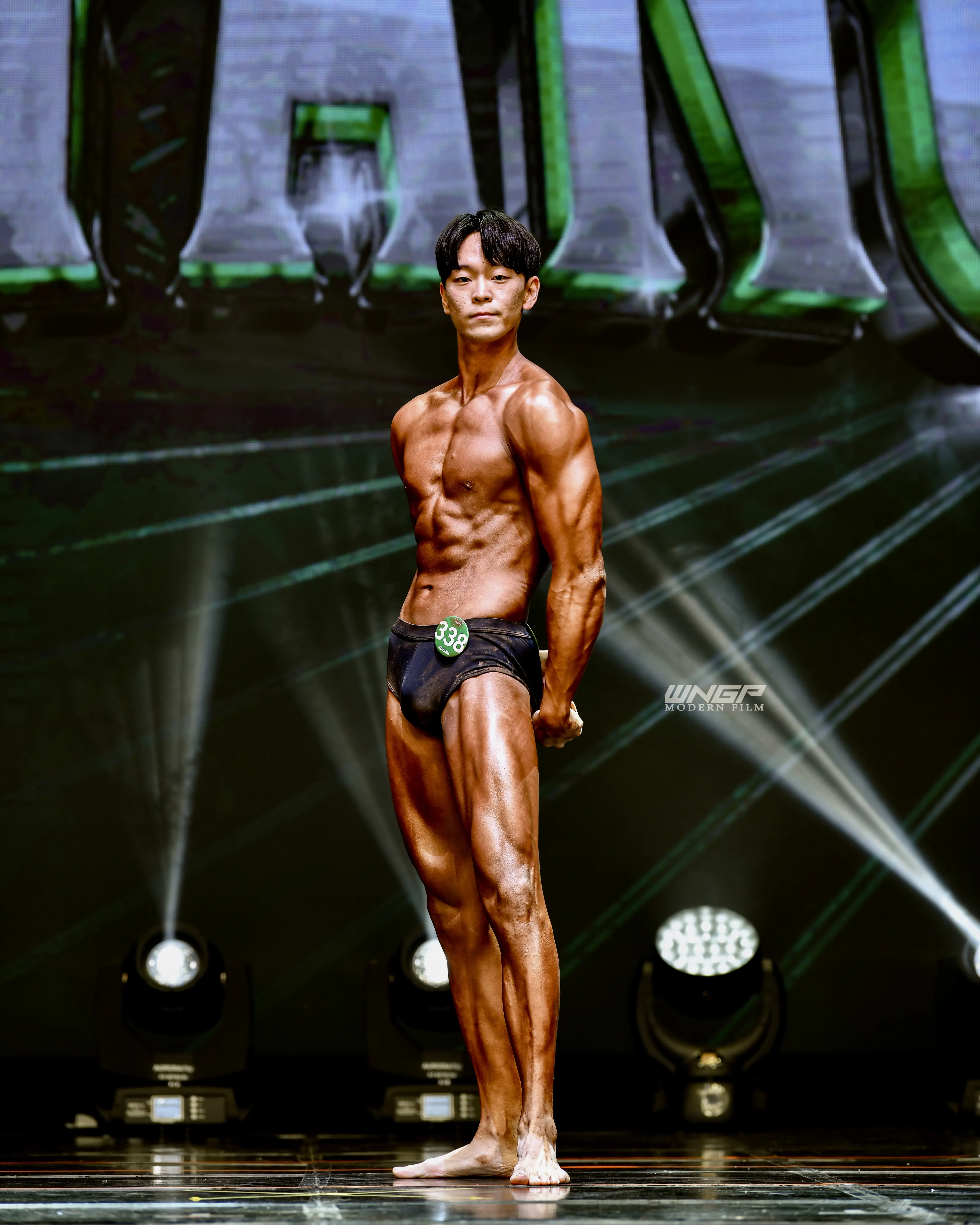 Coach Kang Jaehyun standing pose at natural bodybuilding competition